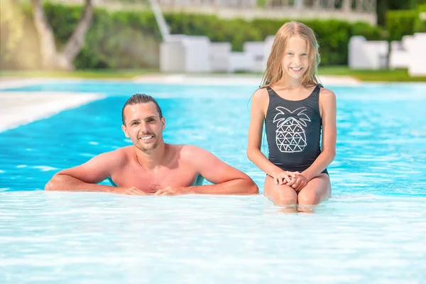 Família de mãe e filha desfrutando de férias de verão na piscina de luxo — Fotografia de Stock