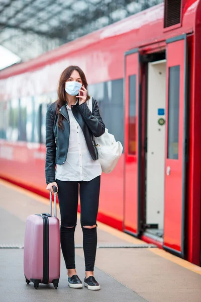 Νεαρή τουρίστρια με αποσκευές στην πλατφόρμα που περιμένει το τρένο — Φωτογραφία Αρχείου