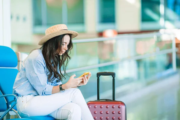 Young woman in hat with baggage in international airport. — Stock Photo, Image