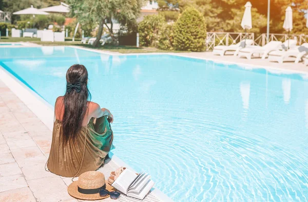 Mulher relaxante na piscina em um resort de hotel de luxo desfrutando de férias perfeitas na praia — Fotografia de Stock