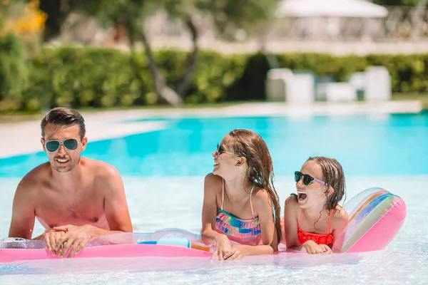 Happy family of three in outdoors swimming pool — Stock Photo, Image