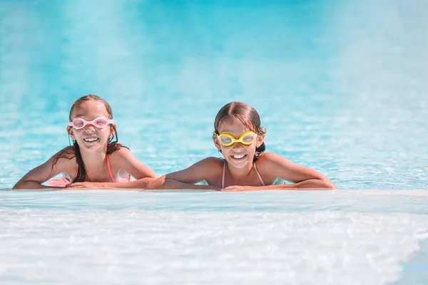 Adoráveis meninas brincando na piscina ao ar livre em férias — Fotografia de Stock