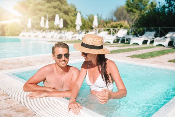 Cheerful couple resting in a swimming pool — Stock Photo, Image