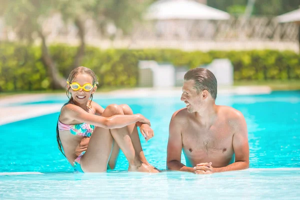 Family of mom and little daughter enjoying summer vacation in luxury swimming pool — Stock Photo, Image