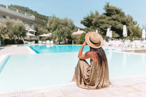 Jovem mulher bonita desfrutando de férias de verão na piscina de luxo — Fotografia de Stock