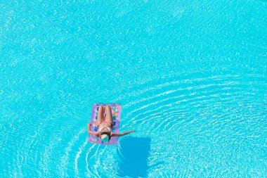 Güzel genç bayan yüzme havuzunda dinleniyor..