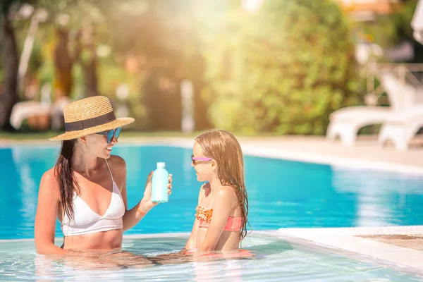 Joven madre aplicando crema solar a la nariz de la hija — Foto de Stock