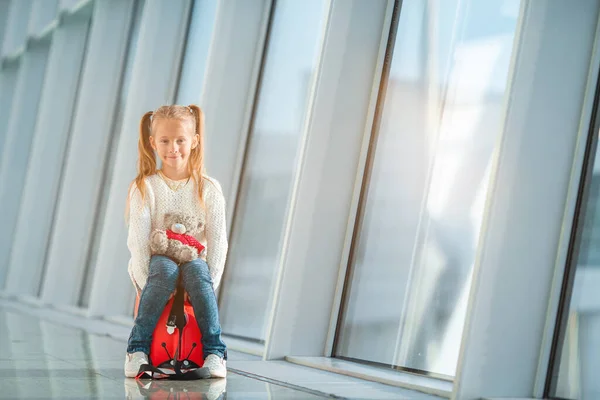 Urocza dziewczynka na lotnisku z bagażem czeka na wejście na pokład. — Zdjęcie stockowe