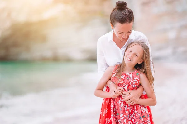 Beautiful mother and daughter at the beach enjoying summer vacation. — Stock Photo, Image