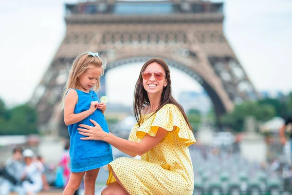 Klein schattig meisje en haar jonge moeder in Parijs in de buurt Eiffeltoren tijdens de zomervakantie — Stockfoto