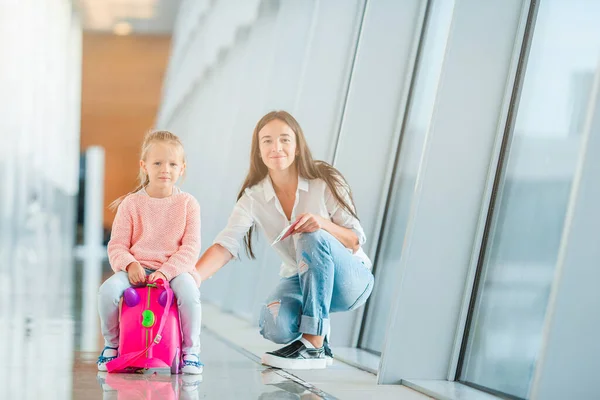 Lycklig mamma och liten flicka med boardingkort på flygplatsen Stockfoto