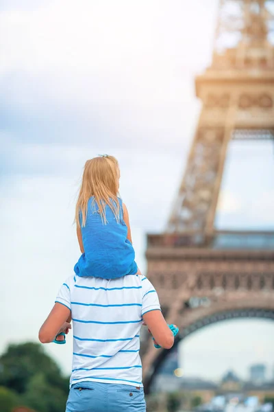 Маленькая симпатичная девочка и ее отец в Париже возле Эйфелевой башни во время летних каникул во Франции — стоковое фото
