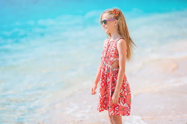 愛らしい女の子持っています楽しいです熱帯のビーチで休暇中 — ストック写真