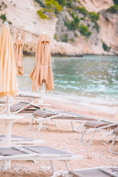 Plaj ahşap sandalyeleri ve Yunanistan sahillerinde tatil için şemsiyeler — Stok fotoğraf