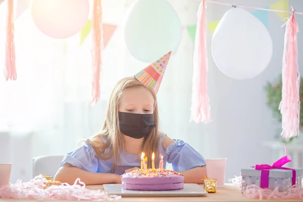 Blank meisje draagt een masker op haar verjaardag. Feestelijke kleurrijke achtergrond met ballonnen. Verjaardagsfeest en wensenconcept. — Stockfoto