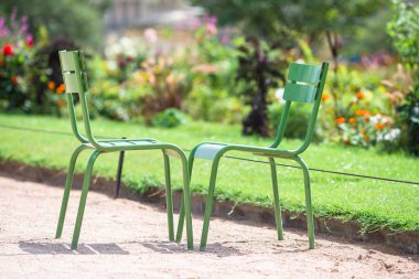Traditional green chairs in the Tuileries garden in Paris, France clipart