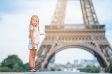 Paris 'teki sevimli küçük kız yaz tatilinde Eyfel Kulesi' nin arka planında