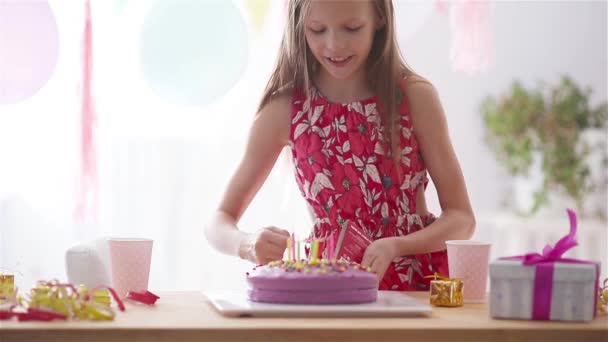 A kaukázusi lány álomszép mosollyal néz a szülinapi szivárvány tortába. Ünnepi színes háttér lufikkal. Születésnapi party és kívánságok koncepció. — Stock videók