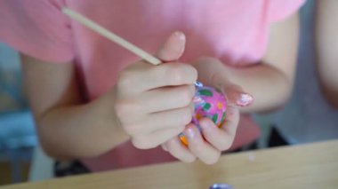 Anne ve küçük kızı yumurta boyuyor. Mutlu aile Paskalya için hazırlanıyor..