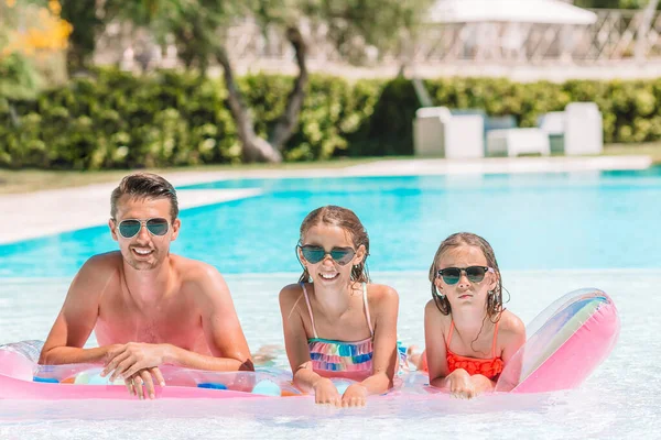 Happy family of three in outdoors swimming pool — Stock Photo, Image