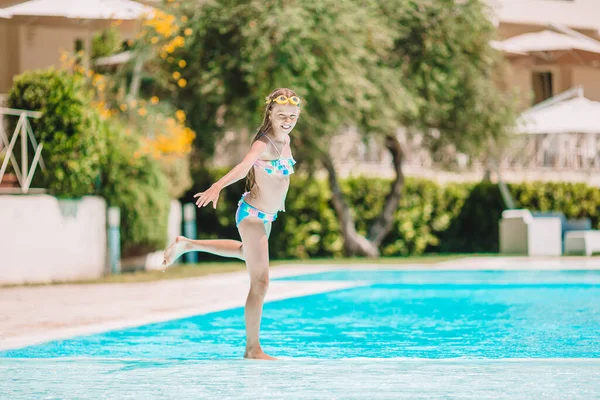 Schattig klein meisje zwemmen bij het buitenzwembad — Stockfoto