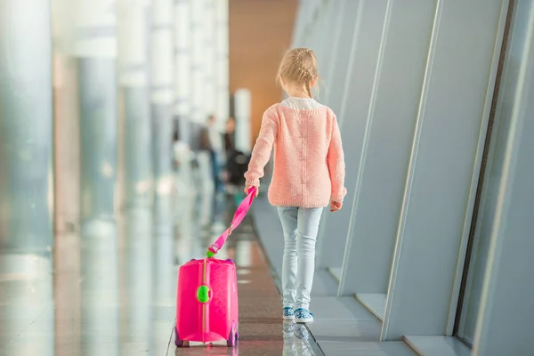 Söt liten flicka på flygplatsen med sitt bagage väntar på ombordstigning — Stockfoto