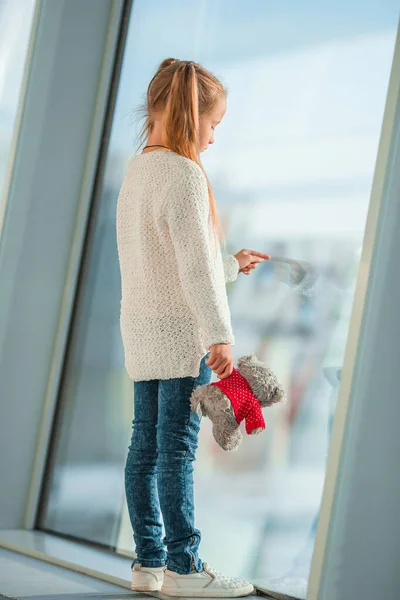 비행기를 기다리는 동안큰 창문 가까이 공항에 있는 어린 소녀 — 스톡 사진
