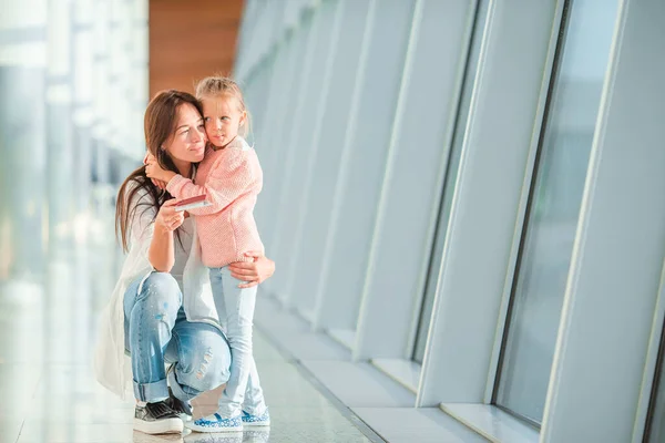 Lycklig mamma och liten flicka med boardingkort på flygplatsen — Stockfoto