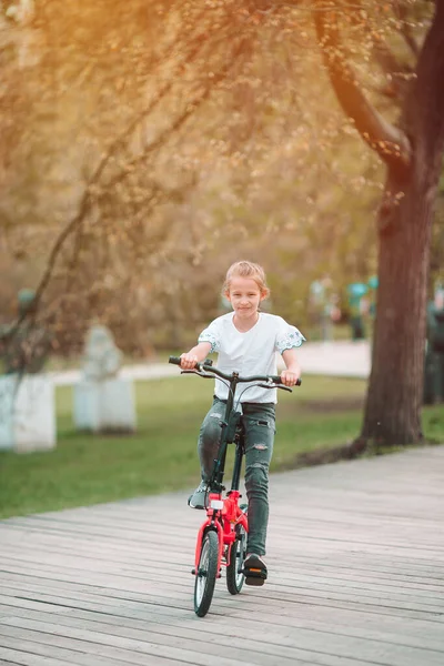 Adorable chica montando una bicicleta en el hermoso día de verano al aire libre — Foto de Stock