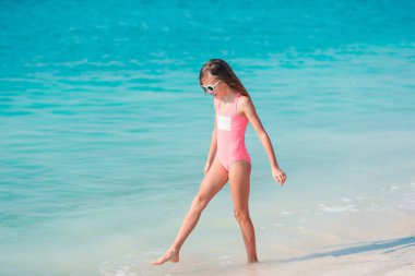 Yaz tatili boyunca sahilde sevimli, aktif küçük bir kız.