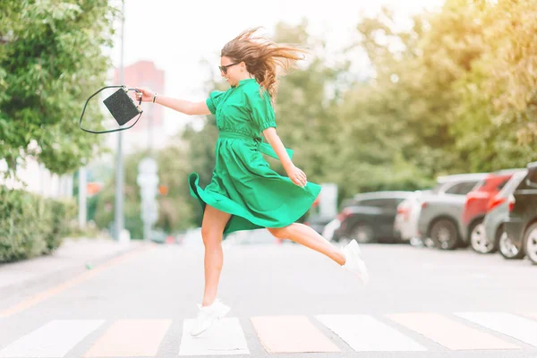 Young woman in green dress in the city walks — Stock Photo, Image