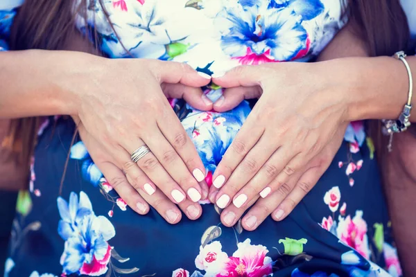 Parents hands making a heart on the belly of the pregnant mother — Stock Photo, Image