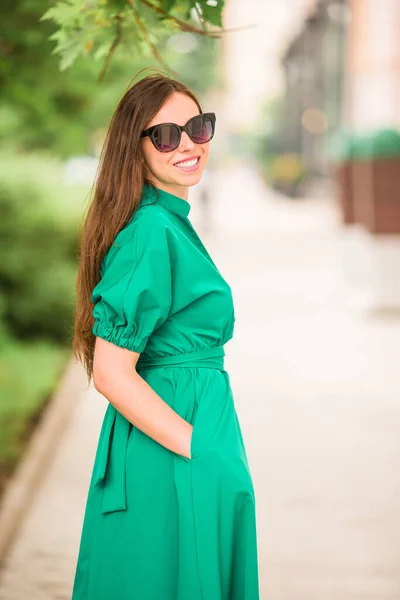 Young woman in green dress in the city — Stock Photo, Image