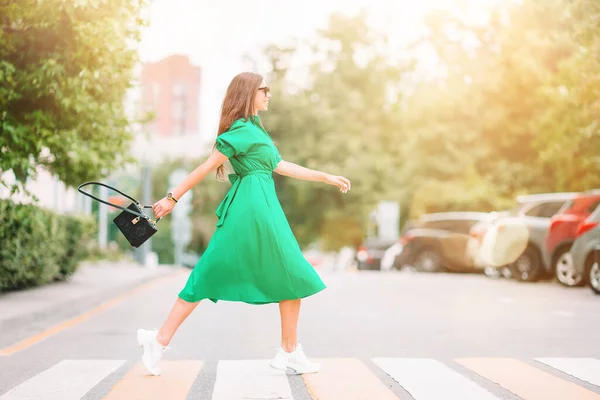 Mladá žena v zelených šatech ve městě procházky — Stock fotografie