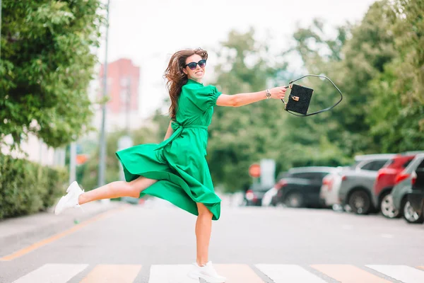 街の緑のドレスの若い女性が歩く — ストック写真