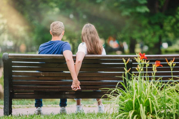 Entspannte junge Familie auf der Bank im Park — Stockfoto