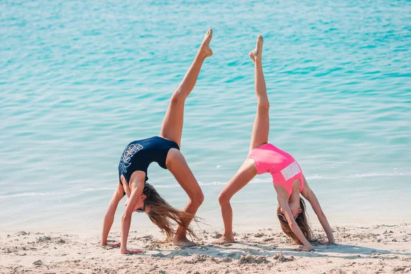 Pequenas meninas engraçadas felizes se divertir muito na praia tropical jogando juntos. — Fotografia de Stock