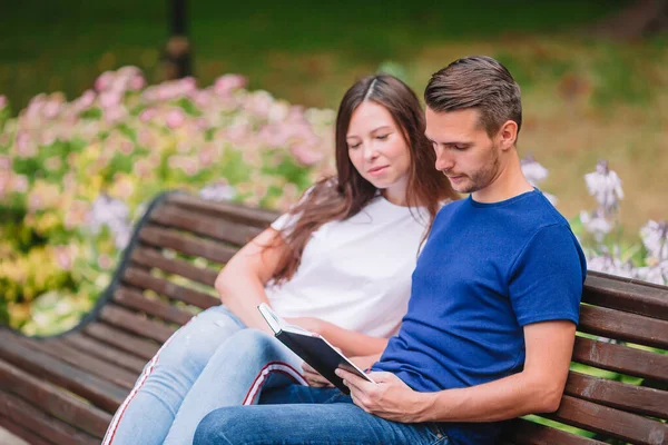 Entspannte junge Familie auf der Bank im Park — Stockfoto