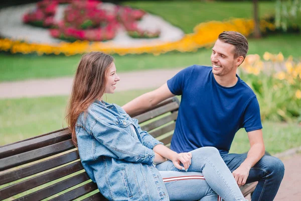 Entspannte junge Familie auf der Bank im Park — Stockfoto