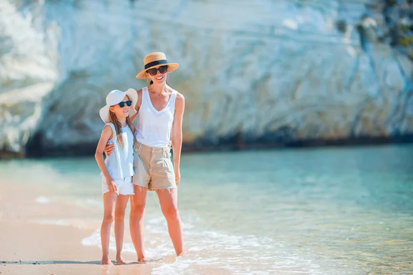 Schöne Mutter und Tochter am Strand genießen den Sommerurlaub. — Stockfoto