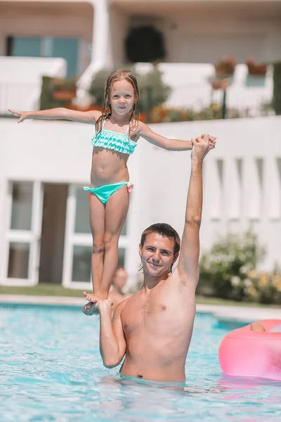 Family of mom and little daughter enjoying summer vacation in luxury swimming pool — Stock Photo, Image