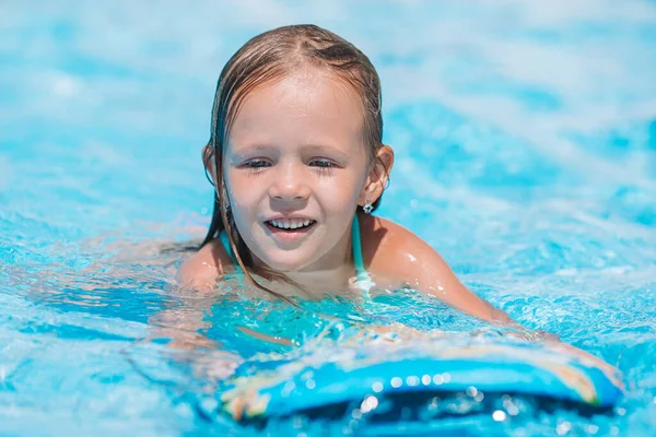 Pequena menina adorável na piscina exterior — Fotografia de Stock