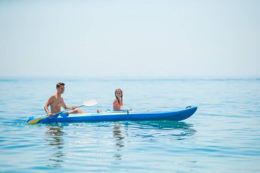 Sportif, çekici bir aile birlikte denizde kayak yapıyor.