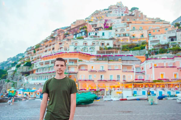 Zomervakantie in Italië. Jonge man in Positano dorp op de achtergrond, Amalfi Coast, Italië — Stockfoto