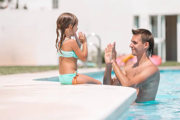 Family of mom and little daughter enjoying summer vacation in luxury swimming pool — Stock Photo, Image