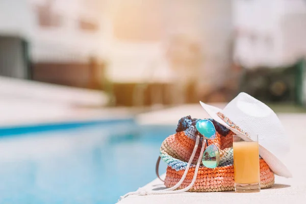 Colorful beach bag, glass of juice, straw hat and airplane model — Stock Photo, Image