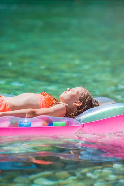 Schattig meisje op opblaasbare lucht matras in de zee — Stockfoto