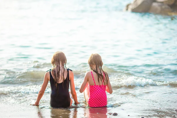 Kleine fröhliche lustige Mädchen haben viel Spaß am tropischen Strand beim gemeinsamen Spielen. — Stockfoto