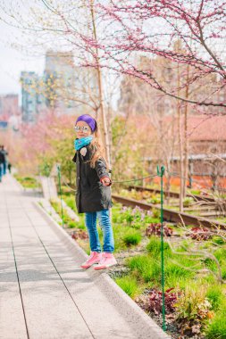 Sevimli küçük kız New York High Line 'da güneşli bir günün tadını çıkar.