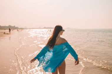 Plajda uzanan kadın yaz tatilinin tadını çıkarıyor ve denize bakıyor.